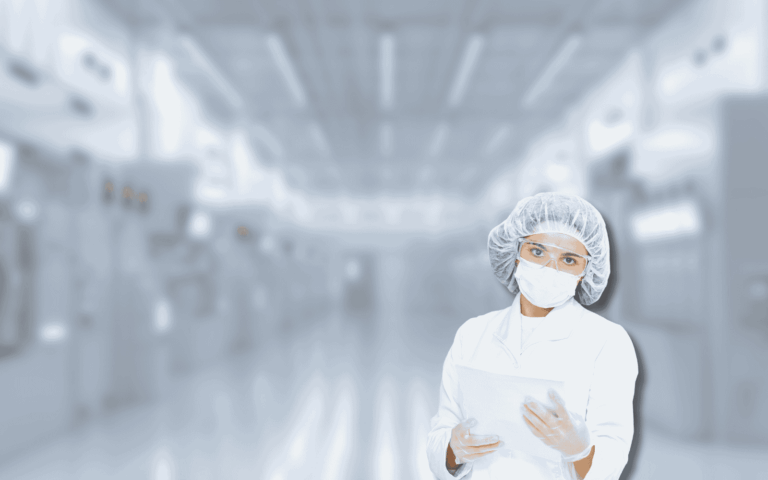 A person in a cleanroom suit holds a tablet in a sterile lab. The setting highlights the importance of MES historian implementation for tracking and improving manufacturing processes in a controlled environment.