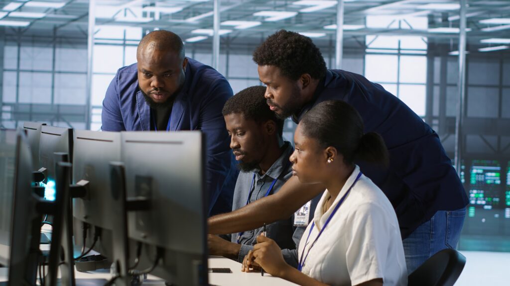 Professional team collaborating on computer workstation for MES implementation project plan development and execution