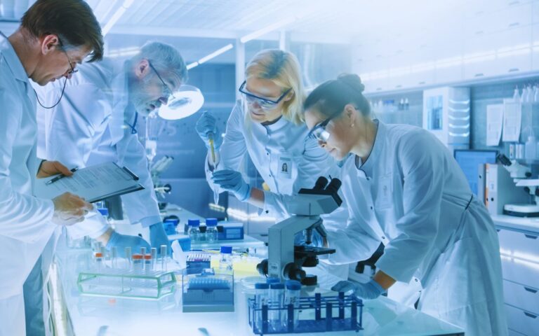 A scientist in a lab working at a computer, highlighting the global cost of preclinical drug failure, with over 60% of candidates failing due to toxicity or efficacy issues.