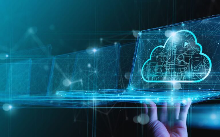 Image of a hand interacting with a holographic cloud interface, representing advanced cloud technology with interconnected digital elements on a laptop screen.