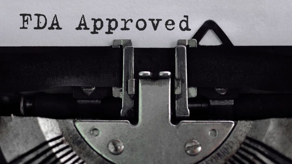 EBR Implementation: Complete Guide for FDA-Regulated Manufacturers 10 Close-up of vintage typewriter with "FDA Approved" typed on paper.