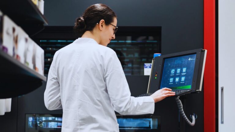 Life Science Project Management Consulting 24 Pharma technician in lab coat using electronic batch record (EBR) system on digital terminal.