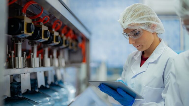 Biotechnology project management consulting 16 Pharmaceutical professional reviewing batch record documentation on tablet to identify and resolve gaps before FDA inspection review