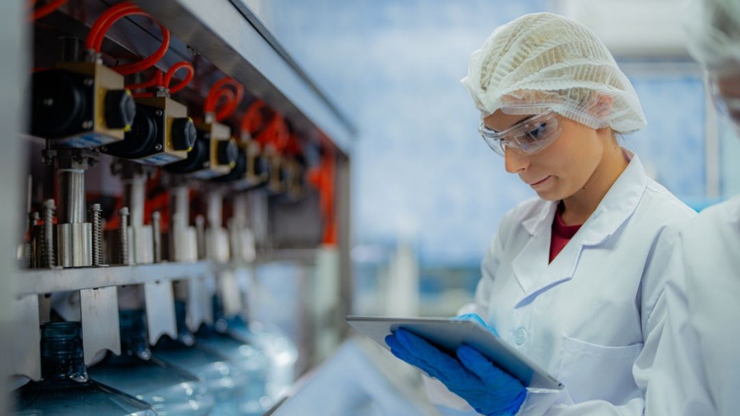 Pharmaceutical professional reviewing batch record documentation on tablet to identify and resolve gaps before FDA inspection review