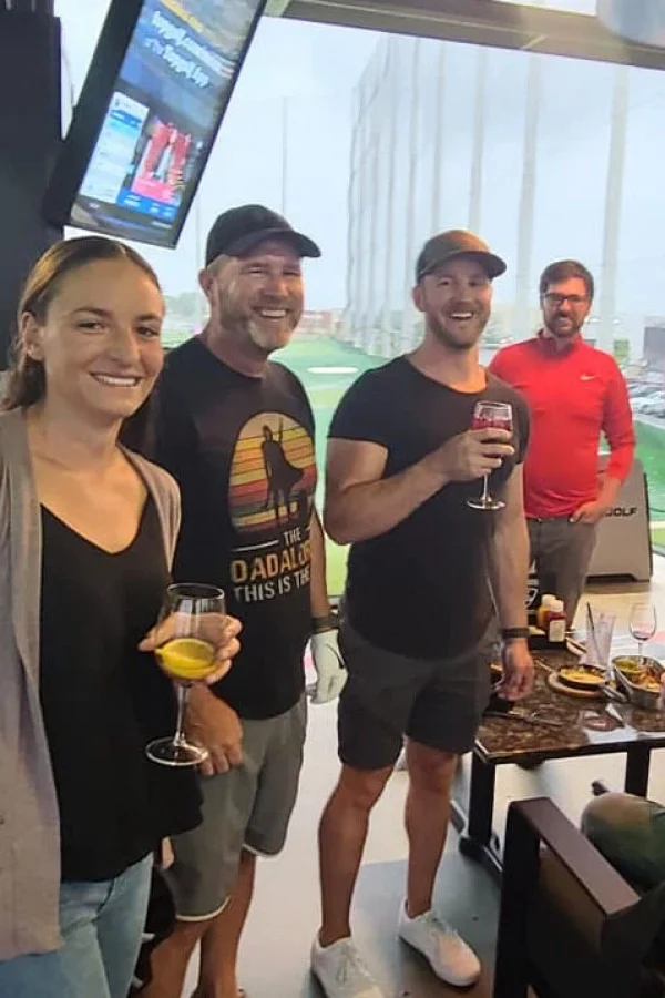 Group of people enjoying a golf event with drinks in hand