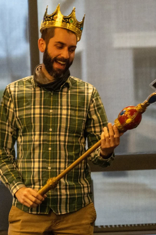 Man wearing a crown and holding a scepter at a Spring Fling event